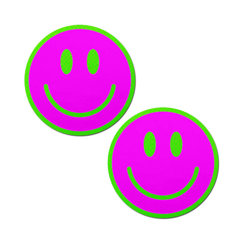 a pair of smiley face breast pasties that are neon green and pink and glow in the darks