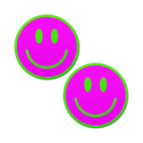 a pair of smiley face breast pasties that are neon green and pink and glow in the darks
