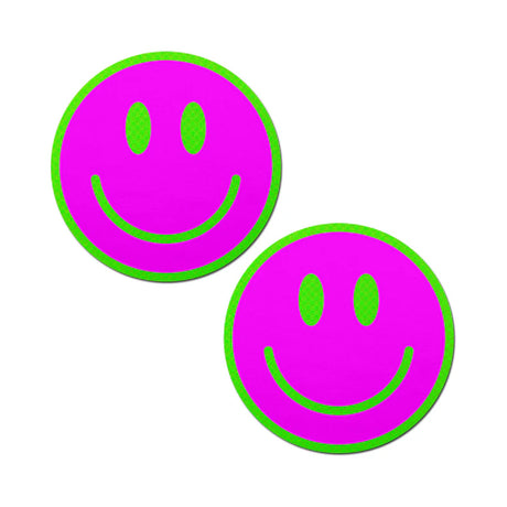 a pair of smiley face breast pasties that are neon green and pink and glow in the darks