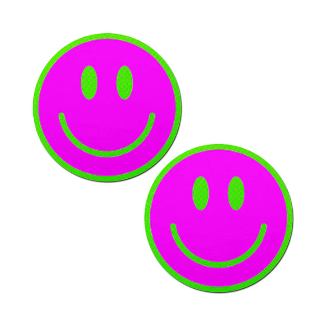 a pair of smiley face breast pasties that are neon green and pink and glow in the darks
