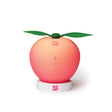 A peach shaped massager in its usb rechargeable docking station
