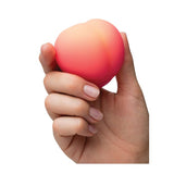 Romp Peach massager being held in hand